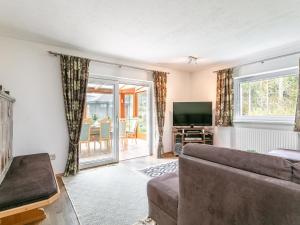 Una sala de estar con un sofá y un televisor. en Landhaus am Waldrand, en Oberndorf in Tirol
