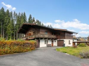 Casa de madera grande con balcón y entrada en Landhaus am Waldrand, en Oberndorf in Tirol