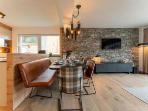 een eetkamer met een tafel en stoelen en een stenen muur bij Grebenzen Lodge Starnberg 60B in Sankt Lambrecht