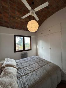 a bedroom with a bed and a ceiling fan at aba casa estudio in Pinamar
