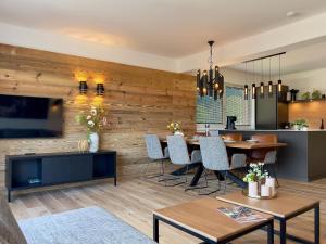 ein Wohnzimmer mit Esstisch und eine Küche in der Unterkunft Grebenzen Lodge Starnberg 60A in Sankt Lambrecht