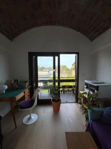 a living room with a door open to a balcony at aba casa estudio in Pinamar