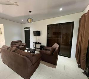 a living room with a couch and two chairs and a table at Casa playa in Huacas