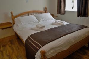 a bedroom with a bed with two towels on it at Sea Breeze Guest House in Douglas