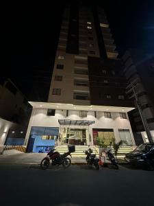 três motos estacionadas em frente a um edifício à noite em Monoambiente moderno y ubicación ideal em Cochabamba