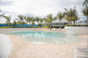 a pool on the beach with palm trees at Cozy Oak - Boho Studio for Couples with Huge Balcony in San Fernando