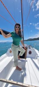 een vrouw die op de boeg van een zeilboot staat bij Veleiro Alpha 22 Privativo in Paraty