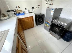 eine Küche mit Kühlschrank und Waschmaschine und Trockner in der Unterkunft Mbao Rufisque bord de mer in Rufisque