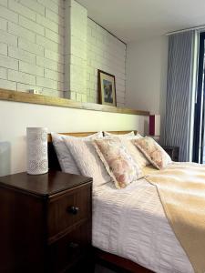 a bedroom with a bed with white sheets and pillows at Koala Cottage in Leongatha +28 photos