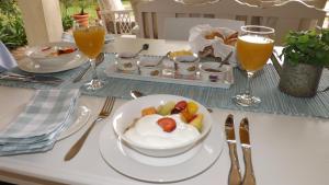 a table with a plate of food and glasses of orange juice at Tiree B&B in Johannesburg