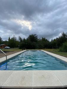 Una gran piscina con agua azul. en Raíces del Ñuble, en San Fabián de Alico
