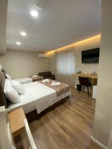 a hotel room with a bed and a desk at Hermes Petite Maison Hotel in Tirana