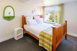 a bedroom with a large bed with a window at Chic Colourful Loft in the Heart of Merivale in Christchurch