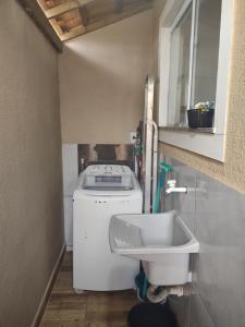 a small kitchen with a washing machine and a sink at Casa com 2 Quartos e Churrasqueira, No Alto da Rasa in Búzios +37 photos
