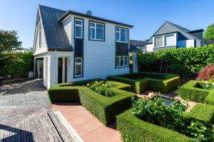 een huis met een tuin ervoor bij Chic Colourful Loft in the Heart of Merivale in Christchurch