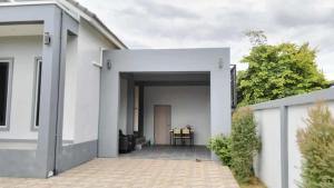 a white house with an open door at SRE- Holiday Home in Prime Village, Mae Sot 