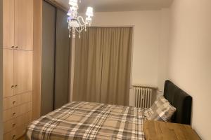een slaapkamer met een tafel en een kroonluchter bij Chambre privée design, 8 min du Parc des Prince et de Roland Garros et à 4 min du métro 9 in Boulogne-Billancourt +1 foto