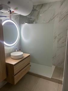 een witte badkamer met een wastafel en een spiegel bij Chambre privée design, 8 min du Parc des Prince et de Roland Garros et à 4 min du métro 9 in Boulogne-Billancourt