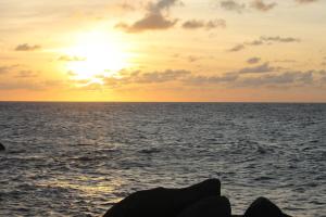 un tramonto sull'oceano con il sole che tramonta di Palm Beach 248 a Palm Beach Altre 4 foto