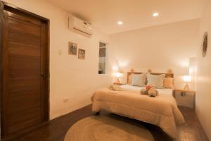 a bedroom with a bed with two stuffed animals on it at Pahinga Villas Siargao in Libertad