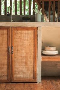 a wooden cabinet with a sink and plates in it at Pahinga Villas Siargao in Libertad +13 photos