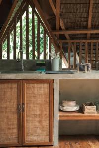 a kitchen with a sink and plates on a counter at Pahinga Villas Siargao in Libertad +22 photos