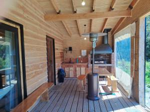 a porch of a log cabin with a table and a stove at Wehuilli Puelo in Cochamó