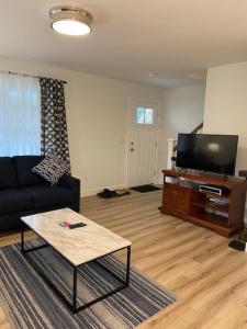 ワーウィックにあるWarwick Rentalのソファと薄型テレビのあるリビングルーム