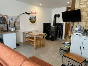 a living room with a couch and a table at Charmant gîte avec terrasse près du Lac de Madine, idéal pour 2 à 4 personnes - FR-1-585-90 in Buxières-sous-les-Côtes +5 photos