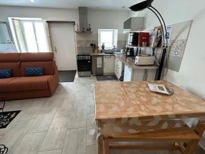 ein Wohnzimmer mit Sofa und Tisch in der Unterkunft Charmant gîte avec terrasse près du Lac de Madine, idéal pour 2 à 4 personnes - FR-1-585-90 in Buxières-sous-les-Côtes + 4 Fotos