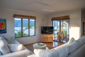 a living room with two couches and a television at Shutehaven Beach House in Shute Harbour +31 photos