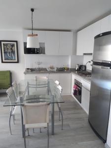 a kitchen with a glass table and chairs in it at Departamento Papudo laguna in Quinquimo