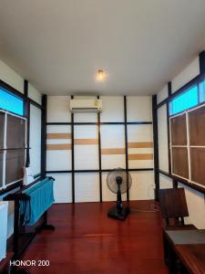 una habitación con ventilador en una habitación con ventanas en nature, en Ban Rong Koet