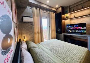une chambre avec un lit, une télévision et une fenêtre dans l'établissement Studio in Twin Lakes Tagaytay, à Laurel