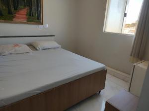 Bett in einem kleinen Zimmer mit Fenster in der Unterkunft Hotel Gold - Brasília in Brasilia