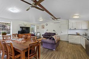 eine Küche und ein Wohnzimmer mit einem Tisch und einer Couch in der Unterkunft Glenrose Cottages in Warwick