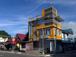 ein gelb-schwarzes Gebäude an der Ecke einer Straße in der Unterkunft Peaks&Pedals Transient in Irosin