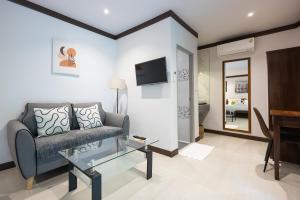 a living room with a couch and a television at Bang Po Hut in Ban Bang Po