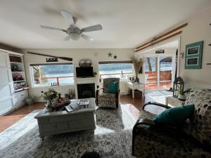 ein Wohnzimmer mit einer Couch und einem Deckenventilator in der Unterkunft Mile 77 Cottages in Youbou