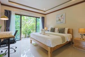 a bedroom with a bed and a desk and a window at Bang Po Hut in Ban Bang Po