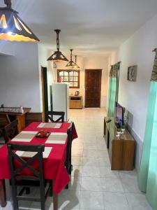 a living room with a table with a red table cloth at Cabaña en el Centro de Mina Clavero in Mina Clavero