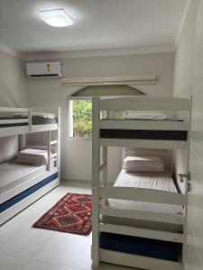 a small room with bunk beds and a window at Apartamento completo, 200mts da praia de Pitangueiras in Guarujá