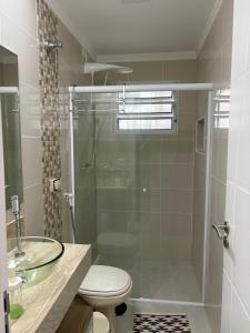 a bathroom with a shower and a toilet and a sink at Apartamento completo, 200mts da praia de Pitangueiras in Guarujá +14 photos