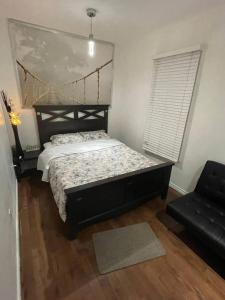 a bedroom with a bed and a black chair at Cherry Berry Niagara Falls in Niagara Falls