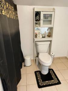 a bathroom with a toilet with a shelf above it at Cherry Berry Niagara Falls in Niagara Falls +15 photos