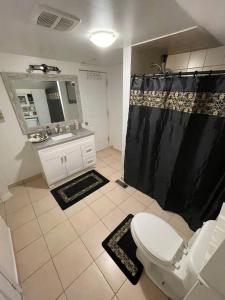 a bathroom with a black shower curtain and a toilet at Cherry Berry Niagara Falls in Niagara Falls