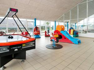 une salle de jeux pour enfants avec une table de billard et des balançoires dans l'établissement 4 person holiday home on a holiday park in Hemmet, à Hemmet