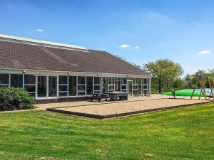 un bâtiment avec un parc et une aire de jeux dans l'établissement 4 person holiday home on a holiday park in Hemmet, à Hemmet