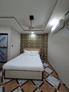 DhangadhiHotel Dev Inn的一间卧室，有一张白色的床和一面砖墙 更多27张照片