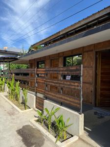 ein Gebäude mit einem Zaun und Pflanzen davor in der Unterkunft Amakan Malinao Apartments for long term rentals only in General Luna